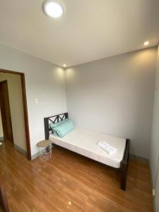 a bed in a room with a white wall at Greenview Terraces in Kay Riapay