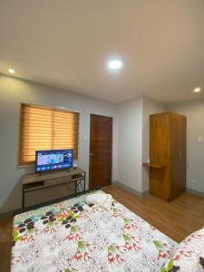 a bedroom with a large bed and a flat screen tv at Greenview Terraces in Kay Riapay