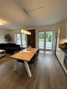 a living room with a wooden table and a kitchen at TOP-Ferienwohnung bei Berlin, bis 3 Gäste, Terrasse und Garten in Bestensee