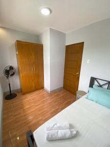 a bedroom with a white bed and a wooden floor at Greenview Terraces in Kay Riapay