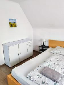 a bedroom with a large white bed and a drawer at Haus in Murfeld Graz in Graz