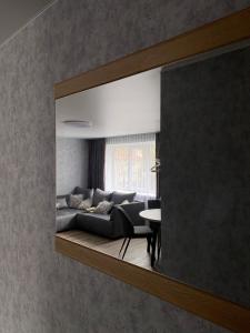 uma sala de estar com um sofá no espelho em Dzīvoklis centrā em Jēkabpils