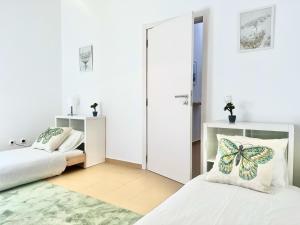 a bedroom with two beds and a butterfly pillow at Maria da Vinha Porto Santo Beach House in Porto Santo