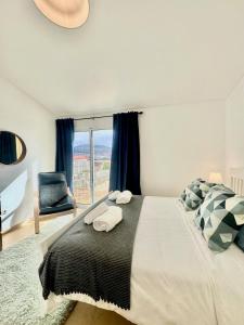 a bedroom with a large bed and a window at Maria da Vinha Porto Santo Beach House in Porto Santo