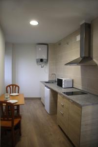 a kitchen with a counter and a table and a microwave at Estudios Playa De Cóbreces in Cóbreces