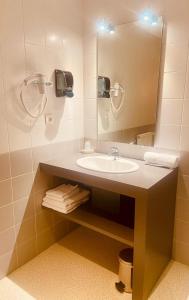 ein Bad mit einem Waschbecken und einem Spiegel in der Unterkunft Restaurant Hôtel du Vercors in Saint-Martin-en-Vercors