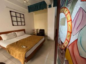 a bedroom with a bed and a painting on the wall at Meera stays in Coimbatore