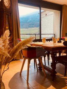 ein Esszimmer mit einem Tisch und einem großen Fenster in der Unterkunft Restaurant Hôtel du Vercors in Saint-Martin-en-Vercors