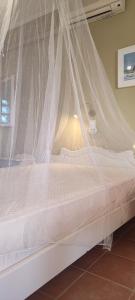 a bed with a mosquito net on top of it at Krinelos Rooms in Skala Eresou