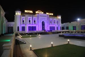 ein weißes Gebäude mit lila Lichtern davor in der Unterkunft HOTEL SULTAN PALACE in Samarkand