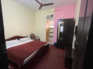 a bedroom with a bed and a pink wall at Meera stays in Coimbatore