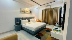 a hotel room with a bed and a desk at Elite 32 Avenue - Near Google Building in Gurgaon