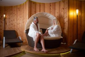 a man and a woman sitting in a bubble bed at Hotel Jesacherhof 4s in Sankt Jakob in Defereggen