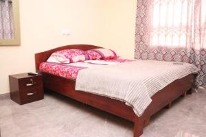 - une chambre avec un lit avec un cadre en bois et une fenêtre dans l'établissement NIKOPS ROYAL HOTEL, à Accra