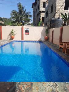 une grande piscine bleue à côté d'un bâtiment dans l'établissement NIKOPS ROYAL HOTEL, à Accra