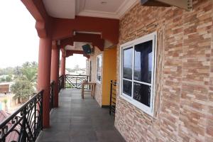 Elle comprend un balcon doté d'un mur en briques et d'une fenêtre. dans l'établissement NIKOPS ROYAL HOTEL, à Accra