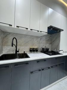 a kitchen with white cabinets and a sink at New apartment in Yunusobod dist. in Tashkent