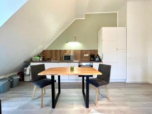 eine Küche mit einem Holztisch und Stühlen in der Unterkunft Apartment Zschachwitz - frisch renovierter Wohlfühlort! in Dresden