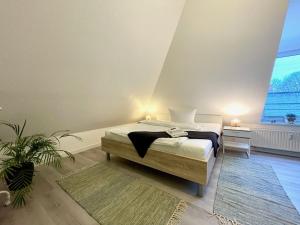 ein Schlafzimmer mit einem Bett und einem großen Fenster in der Unterkunft Apartment Zschachwitz - frisch renovierter Wohlfühlort! in Dresden