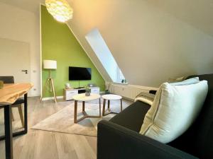 ein Wohnzimmer mit einem Sofa und einem TV in der Unterkunft Apartment Zschachwitz - frisch renovierter Wohlfühlort! in Dresden