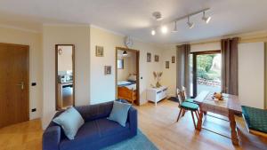 a living room with a blue couch and a table at Ferienappartement WildeAhr - Urlaub beim Winzer! in Rech