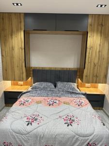 a bedroom with a large bed with a floral bedspread at New apartment in Yunusobod dist. in Tashkent