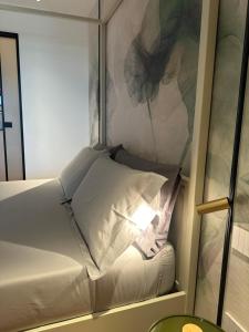 a white bed in a room with a mirror at Azuma Luxury Home in Bari