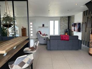 ein Wohnzimmer mit einem Sofa und einem Tisch in der Unterkunft La maison du chêne in Chaignay