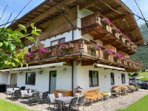 a building with a balcony with tables and chairs at Hotel Acherl in Achenkirch