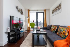 a living room with a couch and a tv at Stevenage - 2 Bedroom Apartment, Free Wifi & Balcony Upto 5 guests in Stevenage
