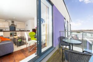 a balcony with a table and chairs and a kitchen at Stevenage - 2 Bedroom Apartment, Free Wifi & Balcony Upto 5 guests in Stevenage