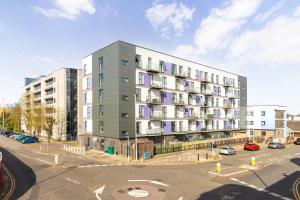 an apartment building on a street with a parking lot at Stevenage - 2 Bedroom Apartment, Free Wifi & Balcony Upto 5 guests in Stevenage
