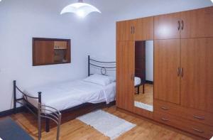 - une chambre avec un lit et une grande armoire en bois dans l'établissement Condominio pelusia, à Modène