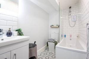 Baño blanco con bañera y lavamanos en MSRSH lux 5, en Mánchester