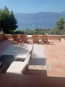 - un ensemble de chaises assises sur une terrasse dans l'établissement Askalosia villa, à Ágios Geórgios