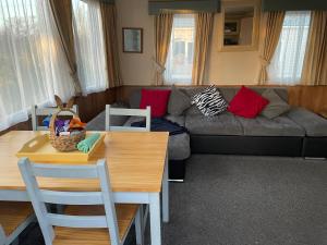 een woonkamer met een bank en een tafel bij Rockley Park- Turlin Valley 36 in Lytchett Minster