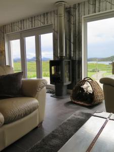 a living room with a couch and a television at Stella Mara Cottage in Aultbea