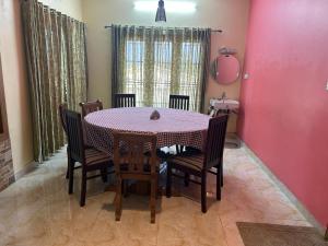 uma sala de jantar com mesa e cadeiras em Madhu Manish Homestay and Rooms em Coonoor