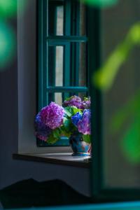 a vase of purple flowers sitting on a window sill at Classique Cavtat Apartment in Cavtat