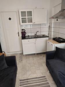 sala de estar con sofá y cocina en Arya en Ayvalık