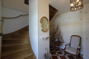 a hallway with stairs and a mirror and a chair at Domaine de Champouteau - Gîtes et Chambres d'hôtes in Averdon