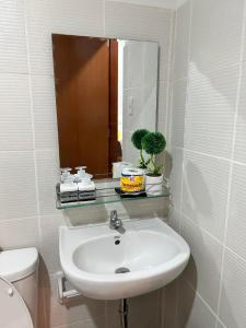 a bathroom with a sink and a mirror and a toilet at KeikaCondo BCD in Bacolod