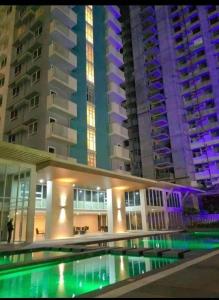 a building with a swimming pool in front of some buildings at KeikaCondo at Mesavirre Garden Residences in Bacolod +7 photos