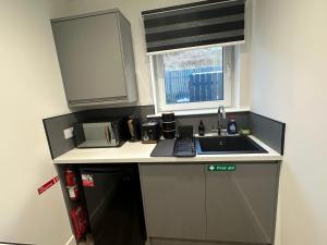 a small kitchen with a sink and a microwave at Burnbrae Apartment in Portree