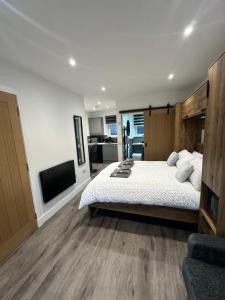 a bedroom with a large bed and a flat screen tv at Burnbrae Apartment in Portree