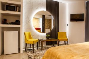 a bedroom with a mirror and two yellow chairs at Limani Comfort Rooms in Thessaloniki