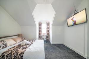 a bedroom with a bed and a tv on the wall at *RB246* For your most relaxed & Cosy stay + Free Parking + Free Fast WiFi * in Knowsthorpe