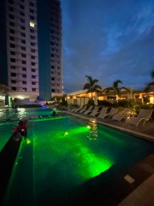 a pool with green lights in a city at night at KeikaCondo BCD in Bacolod