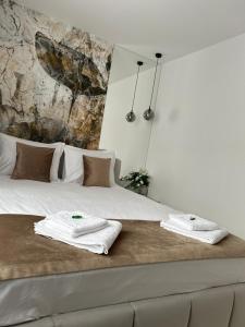 a bedroom with a bed with towels on it at Est One Apartament 2 camere semidecomandat in Drobeta-Turnu Severin