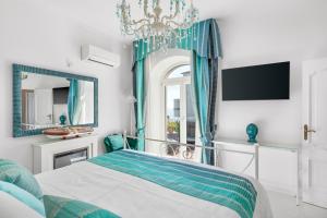 een slaapkamer met een bed en een kroonluchter bij Villa Navarra in Praiano